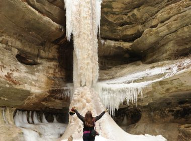 Woman Standing In Front of Frozen Waterfall